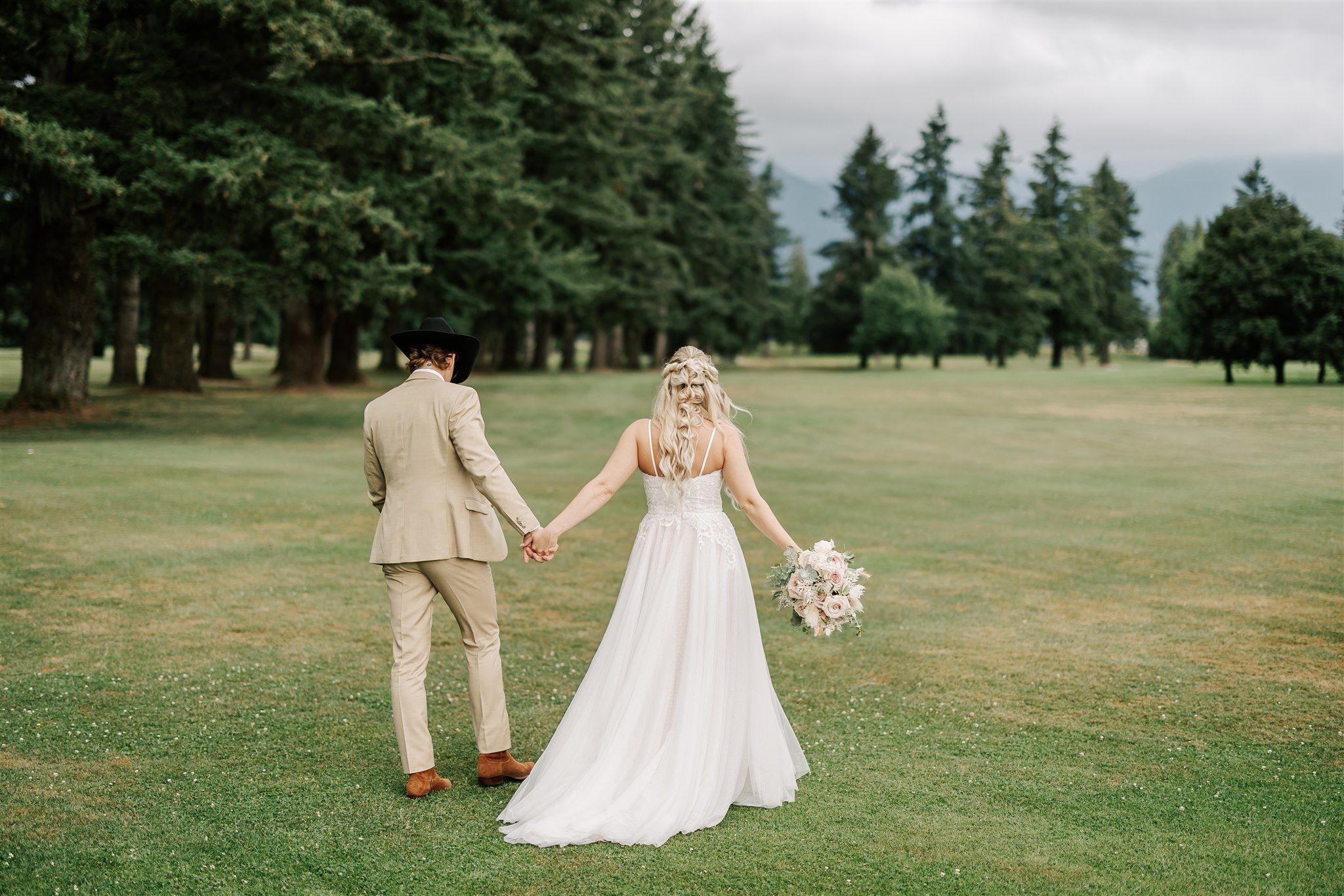 bride and groom walking on the lawn at the golden eagle golf club wedding venue