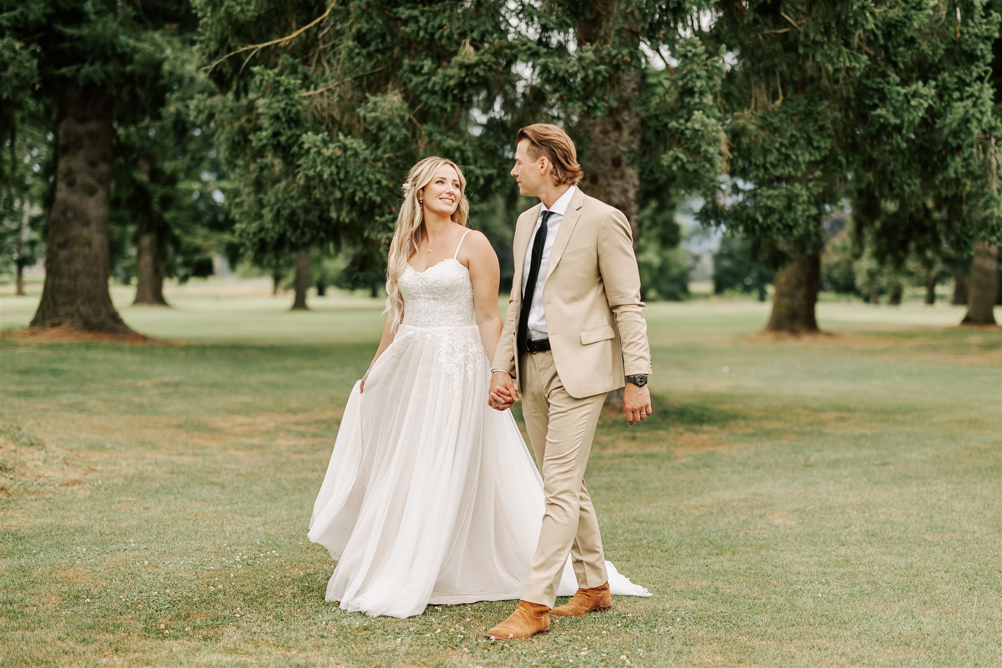 bride and groom walking hand in hand at the golden eagle golf club wedding venue