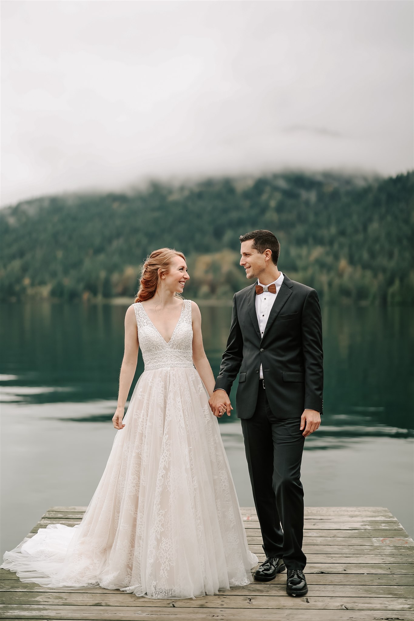 bride and groom standing on a dock holding hands Vancouver Elopement