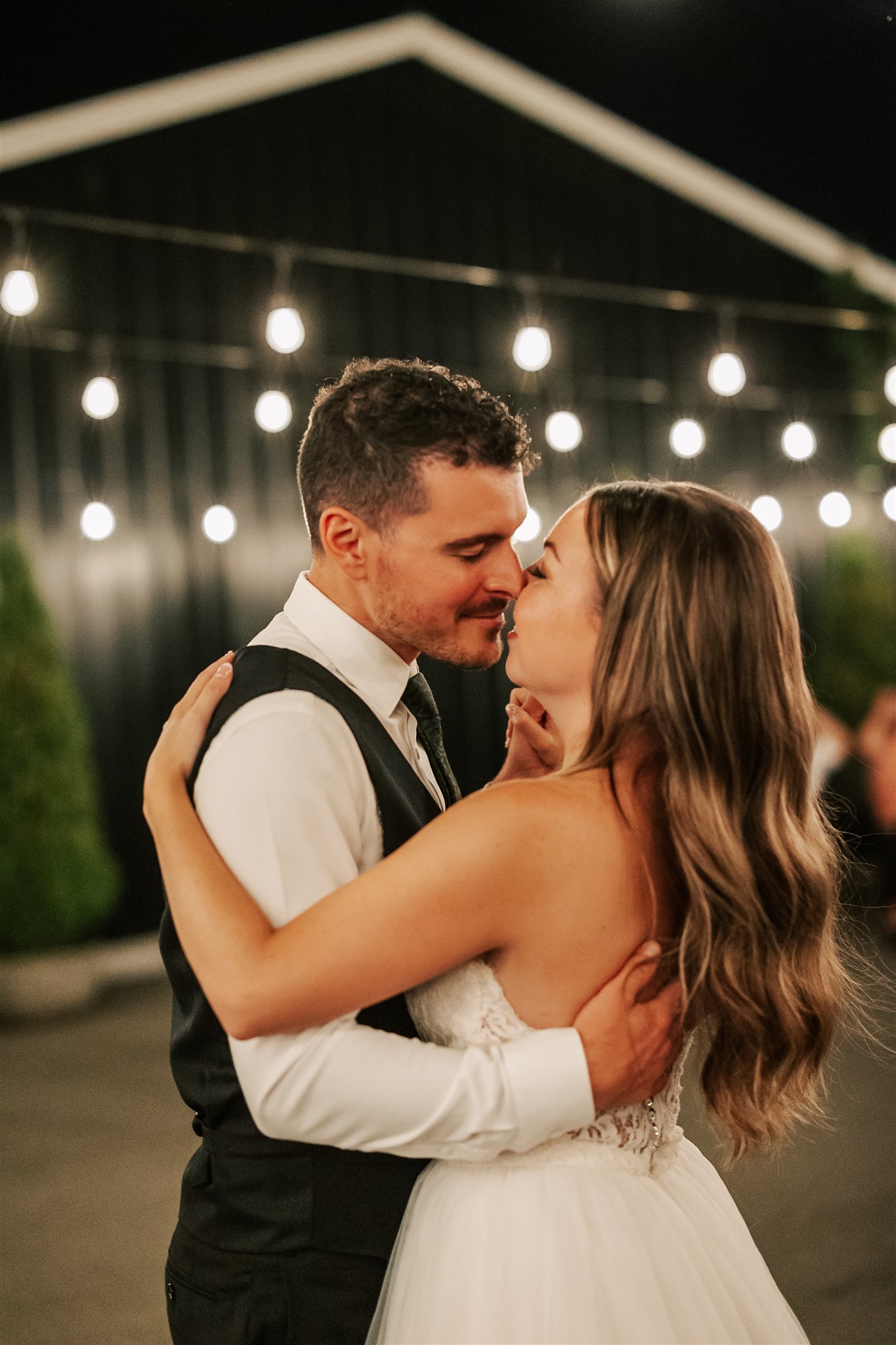 Bride and groom dancing at their reception under market lights Vancouver Wedding Planners