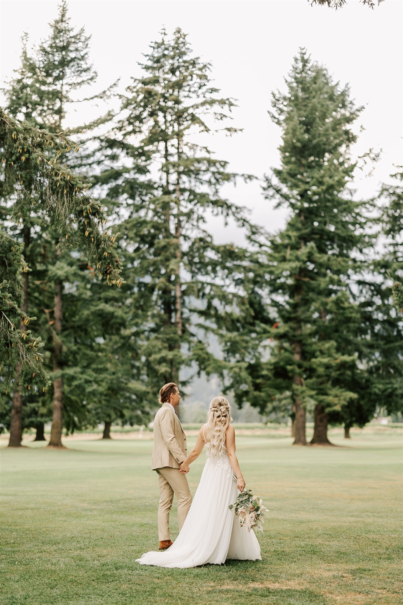 bride and groom holding hands and walking along a golf course Vancouver Wedding Planners